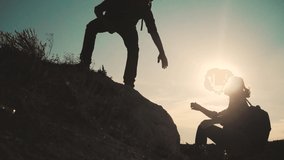 teamwork help business travel. silhouette slow motion video concept. Helping hand silhouette between two climbers. teamwork group of tourists lends helping hand climb the cliffs mountains. couple man