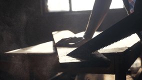 carpenter handmade and craft concept slow motion video. carpenter sawing a tree in a workshop sawing sunlight from a window silhouette. woodworker lifestyle engaged handmade in processing wood at the