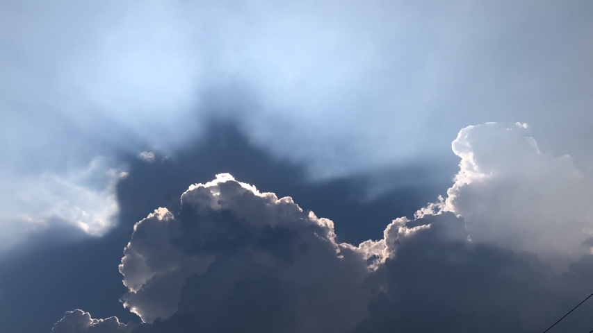 Time lapse footage. Movement of Beautiful dark rain storm clouds reveals the sun, thunderstorm in dramatic sky, with lens flare. Climate cloudscape scenic. Weather tropical  summer squall. Royalty-Free Stock Footage #1038093296