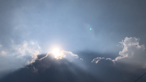 Time lapse footage. Movement of Beautiful dark rain storm clouds reveals the sun, thunderstorm in dramatic sky, with lens flare. Climate cloudscape scenic. Weather tropical  summer squall.