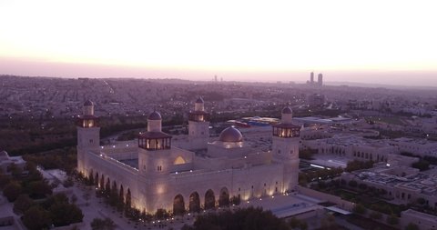 AMMAN, JORDAN - CIRCA 2019 - amazing aerial shot over a mosque in downtown Amman, Jordan as the lights come on at dusk.