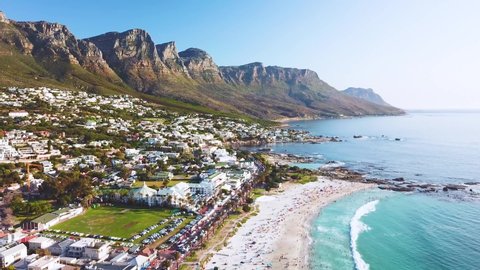 CAPE TOWN, SOUTH AFRICA - CIRCA 2018 - Aerial moving along the shoreline of Camps Bay, Cape Town, South Africa, with Twelve Apostles mountains.