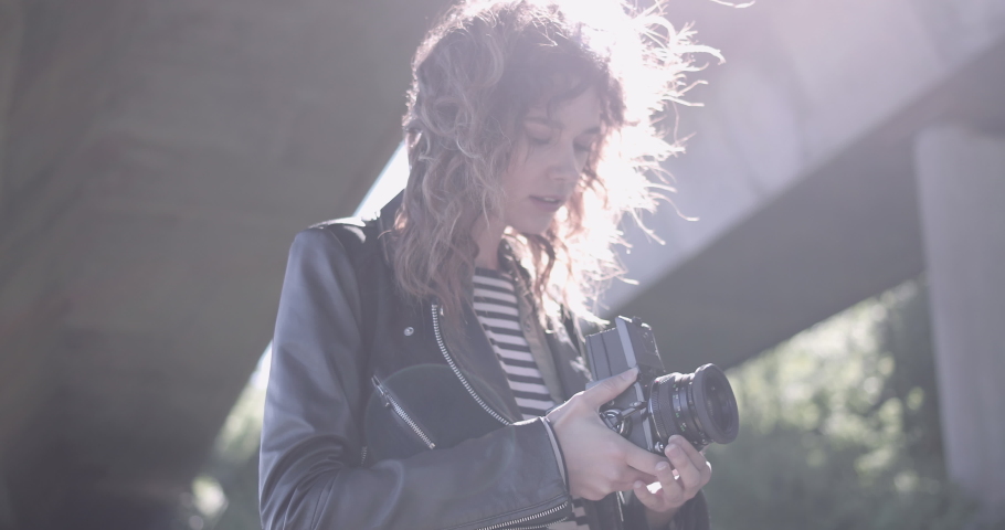 Young Adult woman photographer in urban location with retro camera