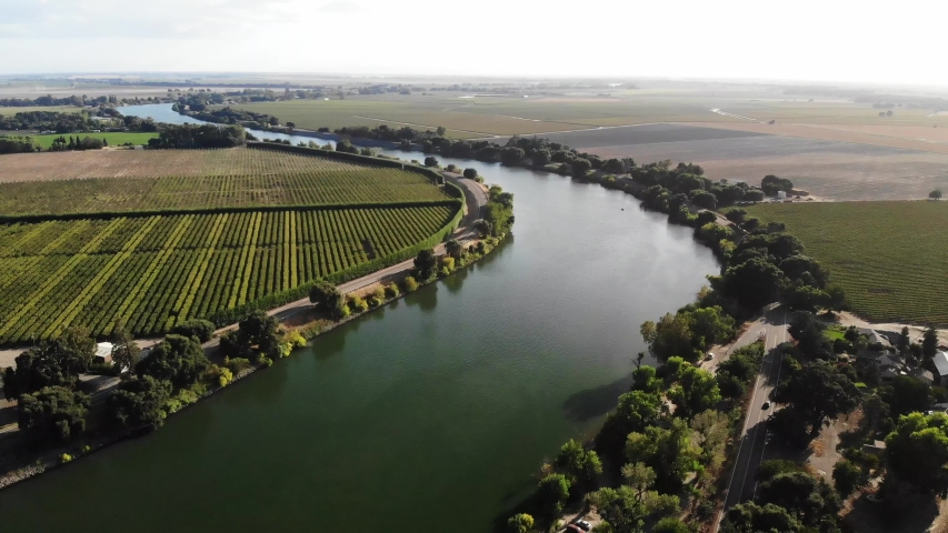 Aerial view of the Sacramento River winding through vineyards and various crops surrounding Clarksburg, California.  | Shutterstock HD Video #1038117761