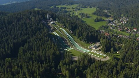Aerial view around the village Hinterzarten in Germany in the black forest on a sunny day in summer. Pan to the right beside the ski jump hill.