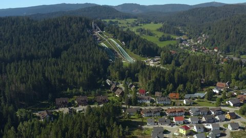 Aerial view around the village Hinterzarten in Germany in the black forest on a sunny day in summer. Close zoom on the ski jump hill.