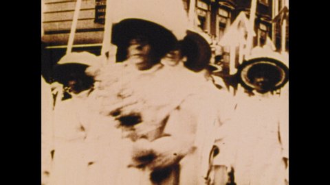 1900s: Women march in parade. Traffic. Police officers arrest women.