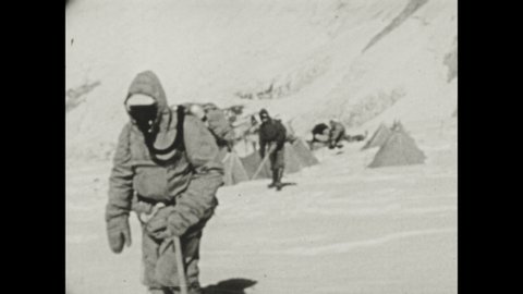 1940s: Hikers leave base camp and start hike up side of Mount Everest. Wind blows snow on Mount Everest.