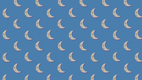 A charming animation featuring a repeated pattern of a crescent moon,ing to the upper left angle, over a blue background.