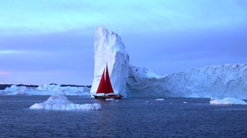 Pan: Red boat passing by glaciers and icebergs in bay - Disko Bay, Greenland