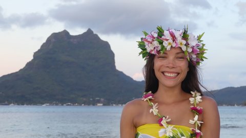 Tahiti beauty woman wearing flower head wreath traditional Tahitian cultural accessory flower crown. Bora Bora, French Polynesia. Beautiful Asian multiracial girl smiling happy.