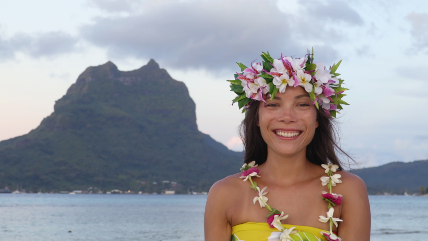 Polynesia tahiti travel icon - Polynesian Welcome with traditional flower Lei. Woman wearing flower head crown giving leis flower necklaces as welcoming gesture for tourism. Mount Otemanu, Bora Bora. Royalty-Free Stock Footage #1038150878