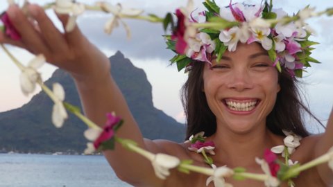 Polynesia tahiti travel icon - Polynesian Welcome with traditional flower Lei. Woman wearing flower head crown giving leis flower necklaces as welcoming gesture for tourism. Mount Otemanu, Bora Bora.