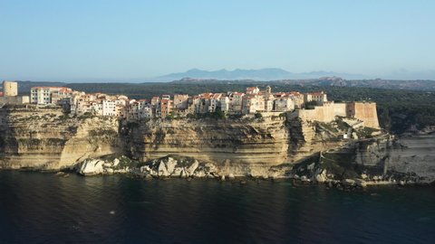 View from above, stunning sunset that illuminates the beautiful village of Bonifacio built on a limestone cliff. Bonifacio is a commune at the southern tip of the island of Corsica, France.