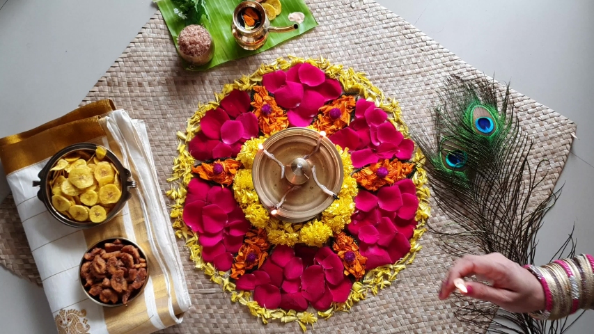 Lighting lamp and traditional flower bed for Onam, harvest festival of Kerala India. Video of fresh flower carpet floral pattern made for Vishu, dussehra, dasara, diwali celebration also. 