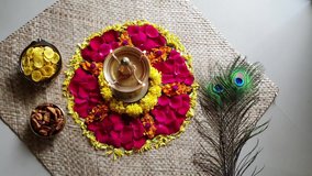 Lighting lamp and traditional flower bed for Onam, harvest festival of Kerala India. Video of fresh flower carpet floral pattern made for Vishu, dussehra, dasara, diwali celebration also. 