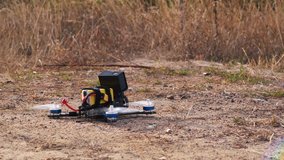 FPV racing drone takes off from a dirt surface raising dust and stones - Powered by Shutterstock - Get 15% off with code: PIKWIZARD15