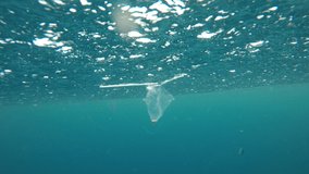 Plastic straws, bags and cups pollution underwater in sea 