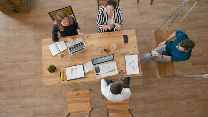 Top View of Casual Diverse Team Applauding to Leader or Manager in Startup Loft Office. Overhead Happy Teamwork Celebrating Success. 4K High Angle Long Background Shot | Shutterstock HD Video #1038179084