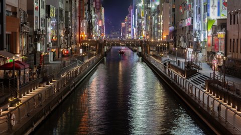 OSAKA/JAPAN - APRIL 30 2019: Timelapse Osaka Dotonbori visitor attraction district on river canal banks with shops restaurants with outdoor advertisements on April 30 in Osaka