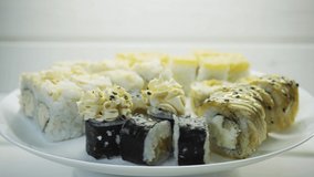 Sushi rolls japanese food rotated over white wood background.Japan restaurant menu. 4K UHD video