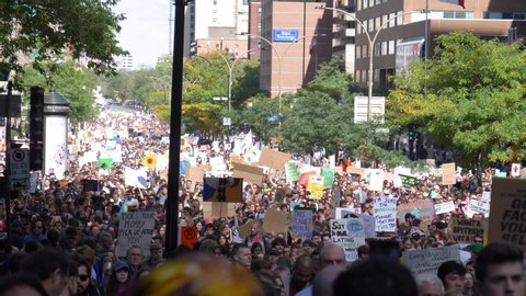A crowd of people protesting about climate change during a street demonstration. Mostly students and young people participating. MONTREAL, CANADA - September 2019