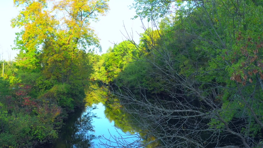 Flying low over tranquil River, Autumn colors beginning, rural Wisconsin, aerial view.
