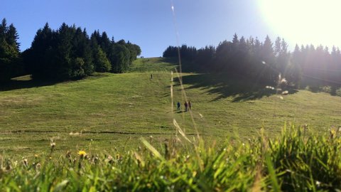 Group of people hiking. Hikers walking down the hill. Outdoor sports recreation activity. Summer holiday vacation tourism. Tourist silhouettes walking. Ski area in Sachticky, Slovakia in summer. 