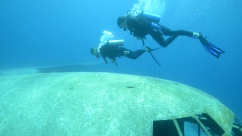 AQABA, JORDAN - CIRCA 2010s - Underwater footage of scuba divers exploring a sunken plane in the Red Sea near Aqaba, Jordan.