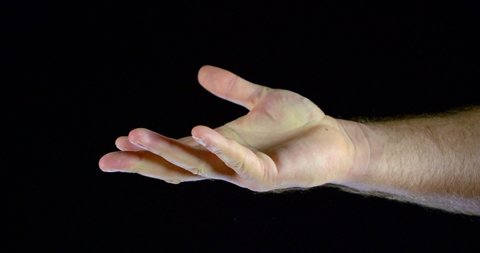 Close - up of a man's hand in a white sleeve on a black background in the Studio, she snaps her fingers.