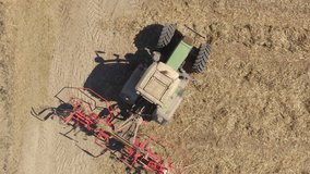 Aerial: Footage of Tractor with blades cutting up dry leftovers from a harvest to prepare the field before fertilizing and seeding.