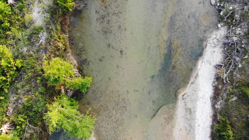 Top down view of river, rising above just to catch a brief glimpse of a small waterfall below. Aerial footage of Blanco river - Wimberly, TX