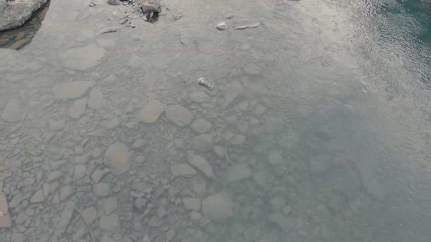 Mountain river and lake surrounded by stones and rocks.  Landscape mountain creek or river.
