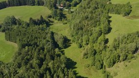 Aerial view of the village Sankt Georgen in Germany  in the black forest on a sunny day in summer. Tilt up to the wind turbines.