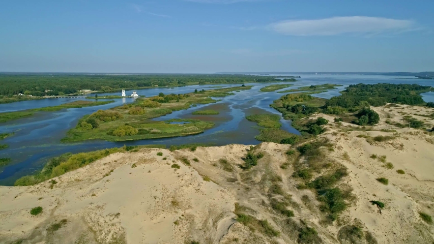 Aerial drone footage. Fly over sand island with church on background