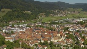 Aerial view of the city Haslach im Kinzigtal in Germany in the black forest on a sunny day in summer. Zoom out from the old town. 