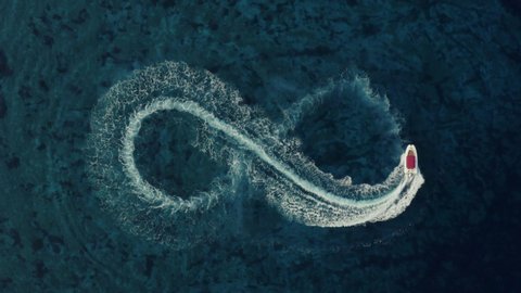 Slowmotion aerial shot of a fast speedboat with a red roof top making an infinity shape in the clear turquoise magical sea. Top travel destination. Love symbol. 4K.