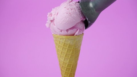 Strawberry ice cream scoop in waffle cone on pink background, Closeup Front view Food concept, Full HD.