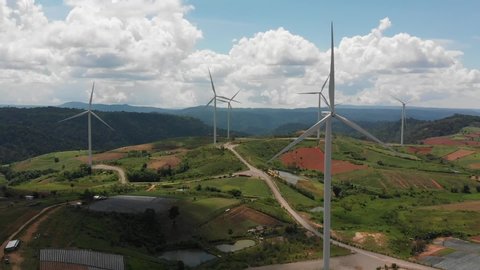 Wind turbine farm on beautiful mountain landscape. Renewable energy production for green ecological world. Aerial view of wind mills farm park on evening mountain.