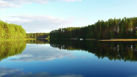 Flying over the lake on a drone. Reflection in the lake. Forests of North Karelia