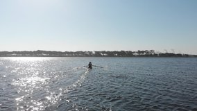 Zoom in follow shot of a team of two young adult Caucasian women rowing in two racing shells on a river during training in slow motion - Powered by Shutterstock - Get 15% off with code: PIKWIZARD15