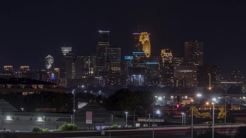 MINNEAPOLIS, MN - JULY 2019 - A Telephoto Shot of Traffic Blurring Past Downtown Minneapolis and a Summertime Fireworks Celebration over the Skyline at Night