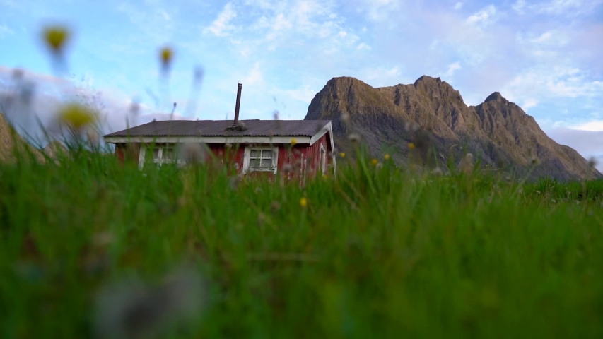 A red small house in the mountains. Jib camera movement . From Ørsta, Norway.