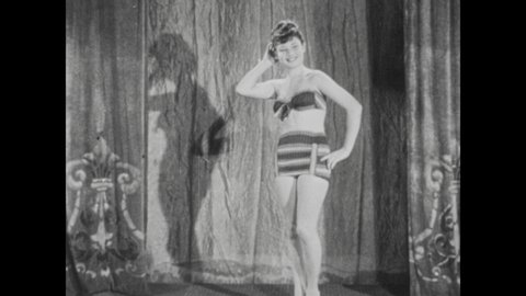1940s: Woman in swimwear poses on stage. Male bodybuilder poses and flexes on stage.