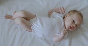 Caucasian cute newborn baby laying on white blanket. RAW Graded footage 4K slow motion 50fps