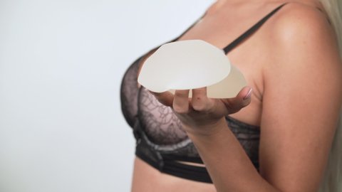 
blonde girl shows, examines, plays with silicone implants for breast augmentation