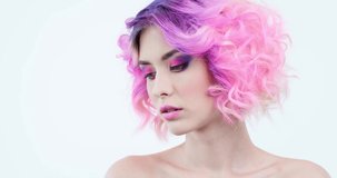 Stylish woman with fashion hairstyle. Closeup portrait of a fashion model with bright purple hair. Beauty face with a pink makeup. Fashionable girl.  Woman turns her head  and looks to the camera.