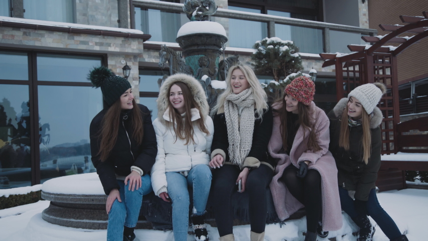 Happy girls resting with smiles at house on snowy area. 4K