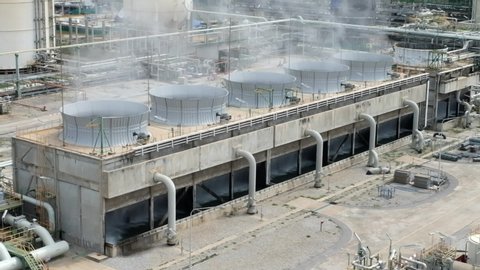 Cooling tower and cooling fan blowing steam on the air in chemical plant, refinery plant, oil and gas plant during operation.