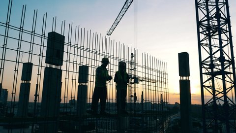 Men work on a construction site on a sky background.